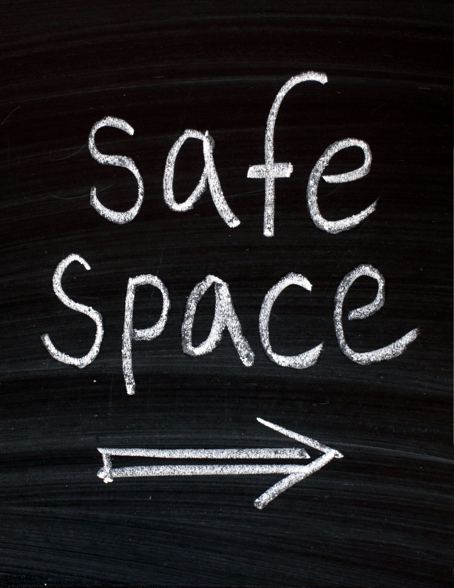 Handwritten white chalk text reading 'safe space' on a black chalkboard with a right-pointing arrow.